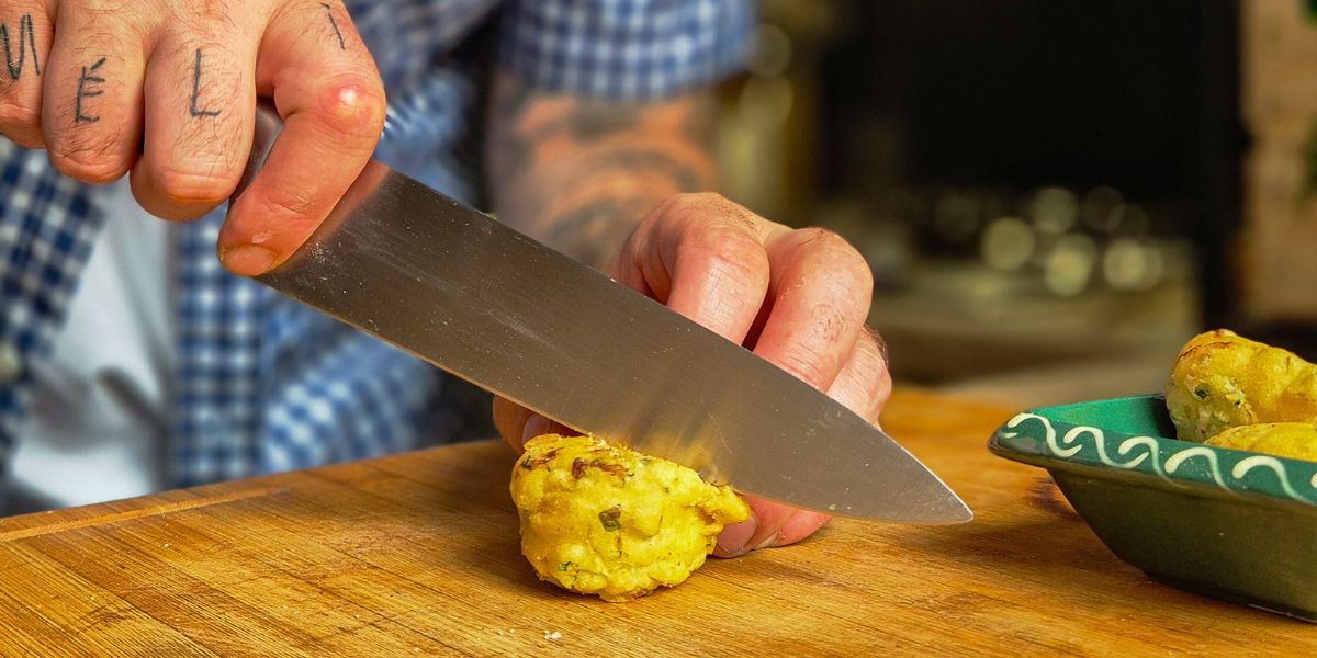 L'amijoteur coupant un beignet de courgette